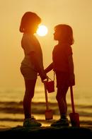Two young girls enjoy the sunset at Borth near Aberystwyth, Mid Wales. 